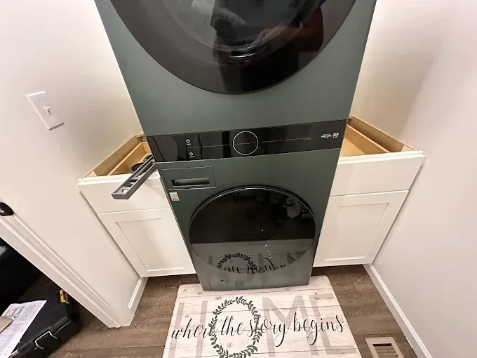 A washer and dryer are stacked on top of each other in a laundry room.