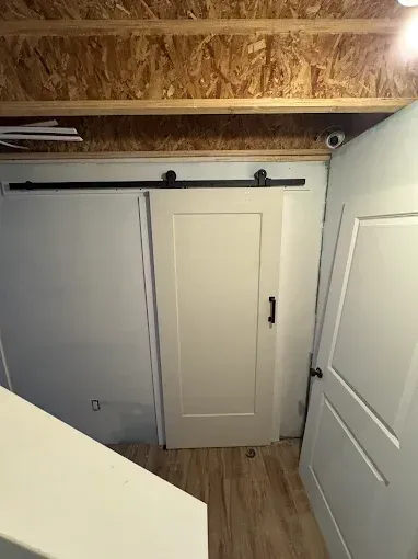 There is a sliding barn door in the corner of the room.