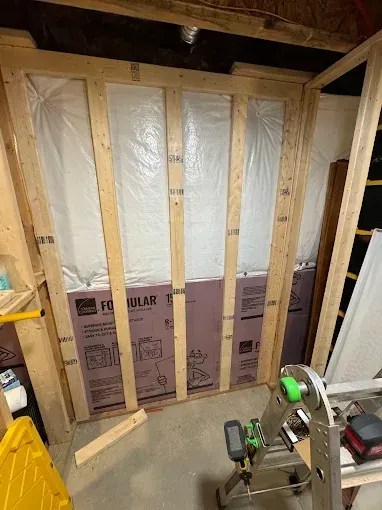 A room is being built with wooden beams and insulation.