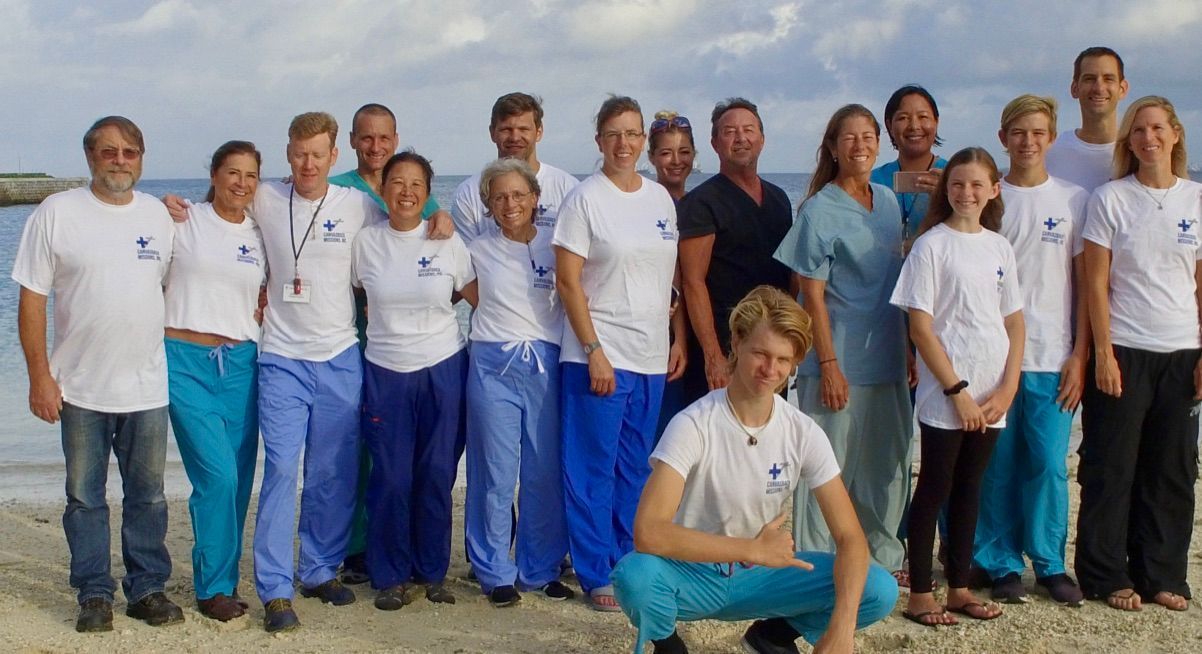 A group of people posing for a picture on a beach