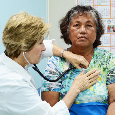A doctor is listening to a patient 's heart with a stethoscope.