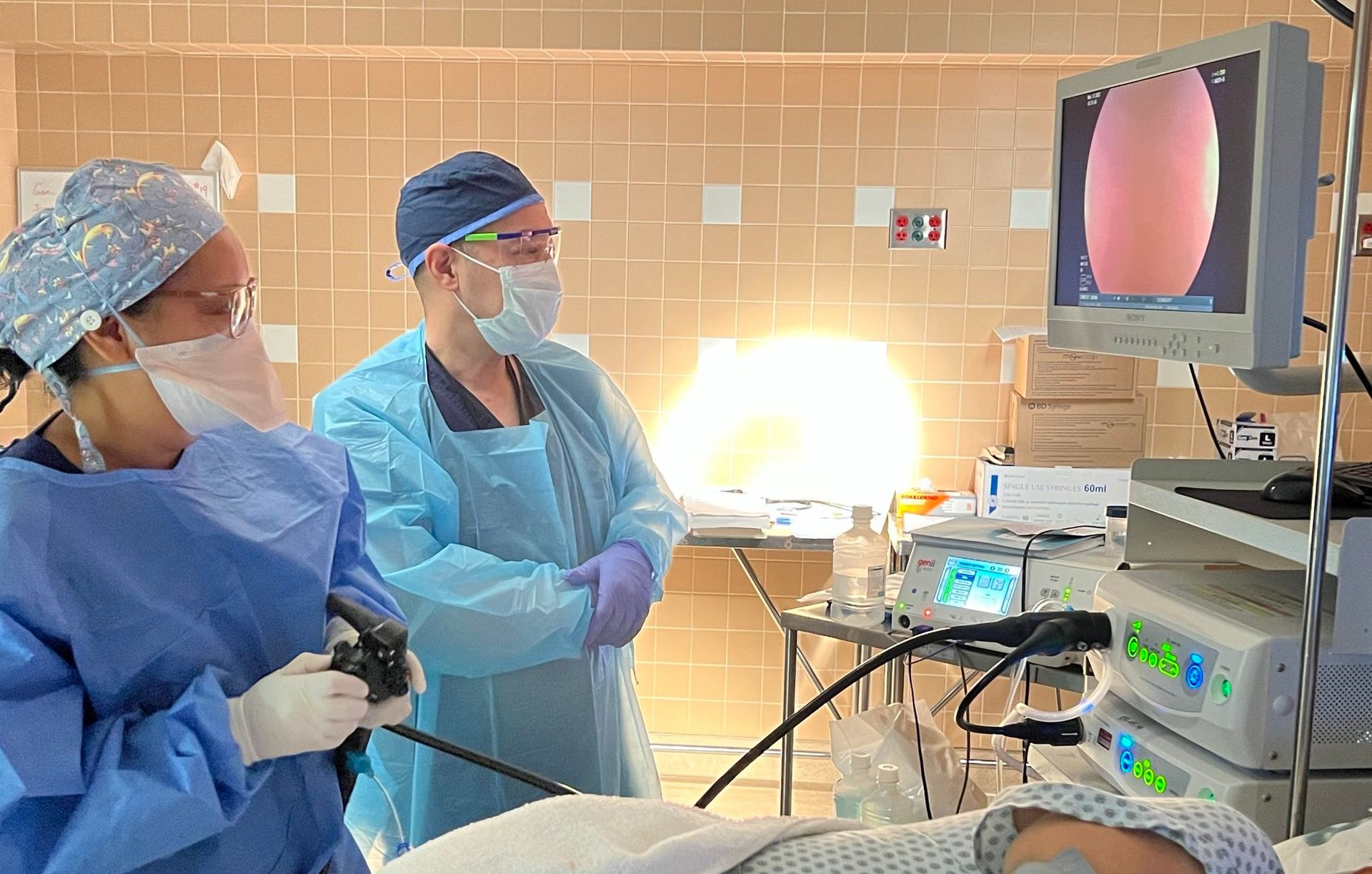A man and a woman are operating on a patient in an operating room.