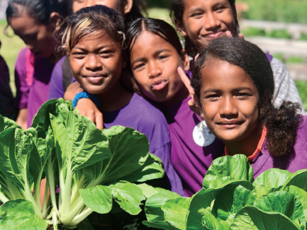 A group of young girls in purple shirts are posing for a picture