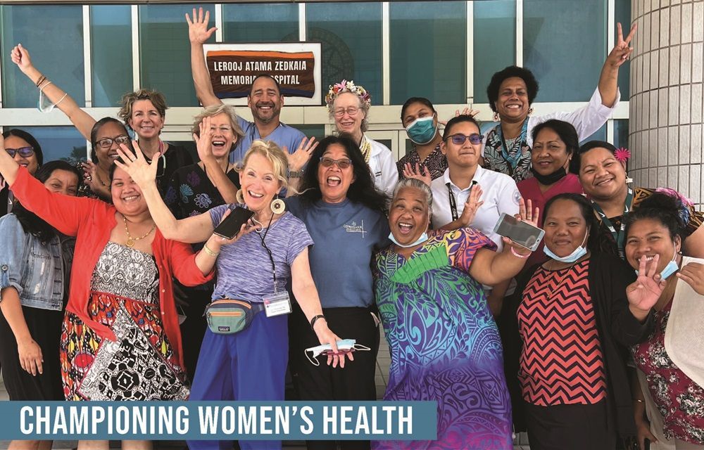 A group of women are posing for a picture in front of a building.