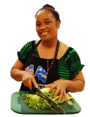 A woman in an apron is cutting lettuce on a cutting board