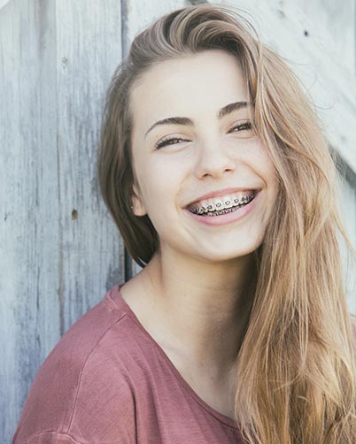 Adult Braces — Smiling Girl with Braces in Waterloo, IA