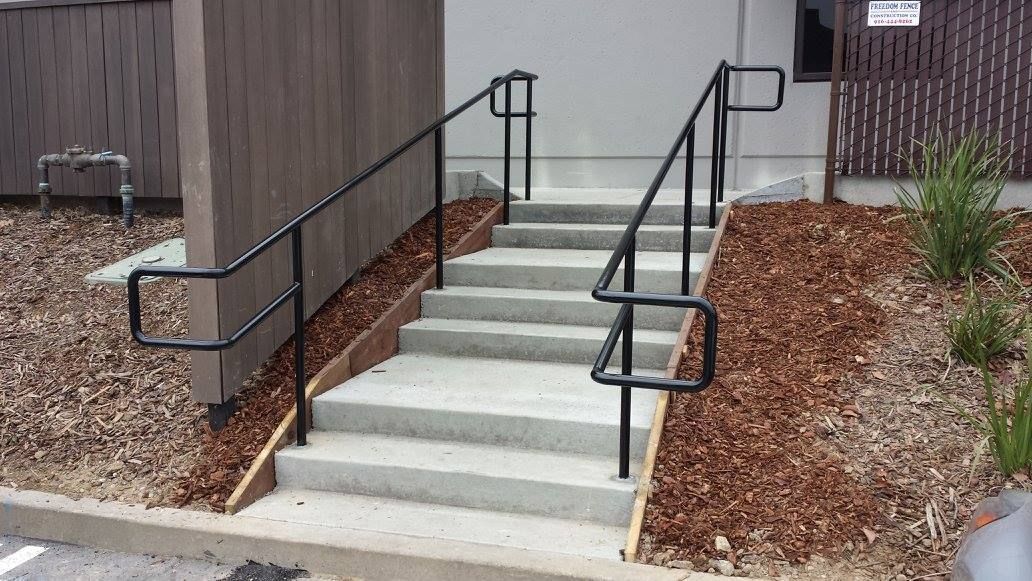 A set of stairs with a metal railing leading up to a building.