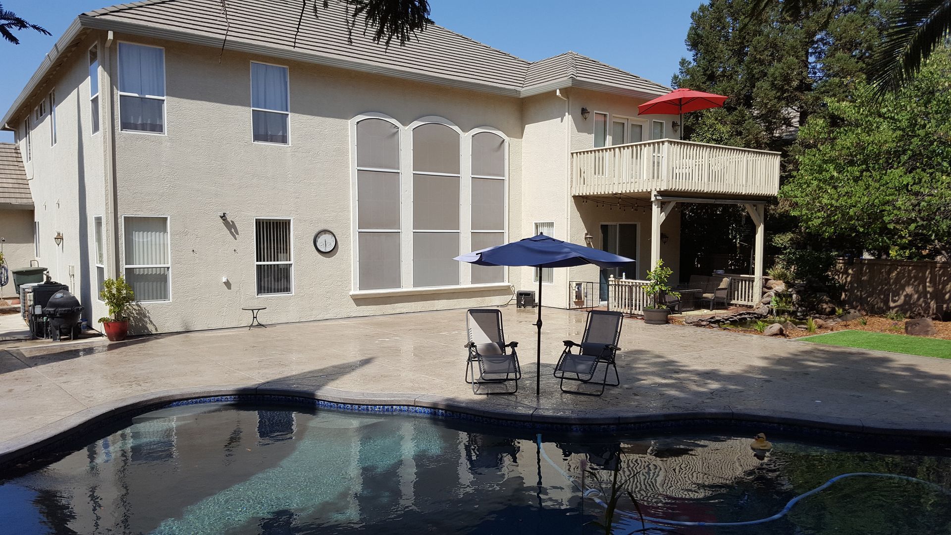 A large house with a swimming pool in front of it