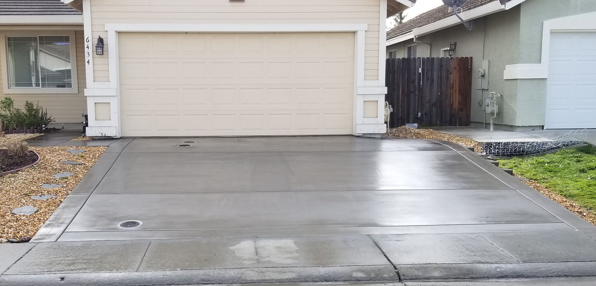 A concrete driveway in front of a house with a garage door.