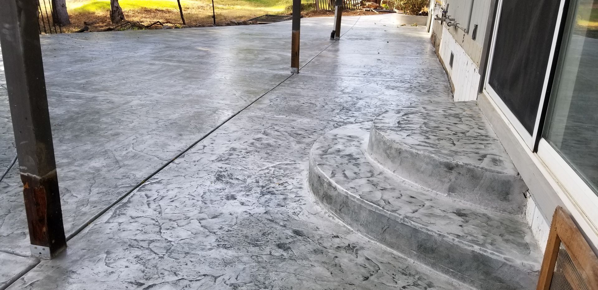 A concrete walkway with stairs leading up to a house.