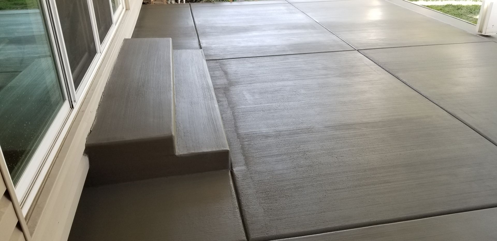 A concrete walkway with steps leading up to a house.