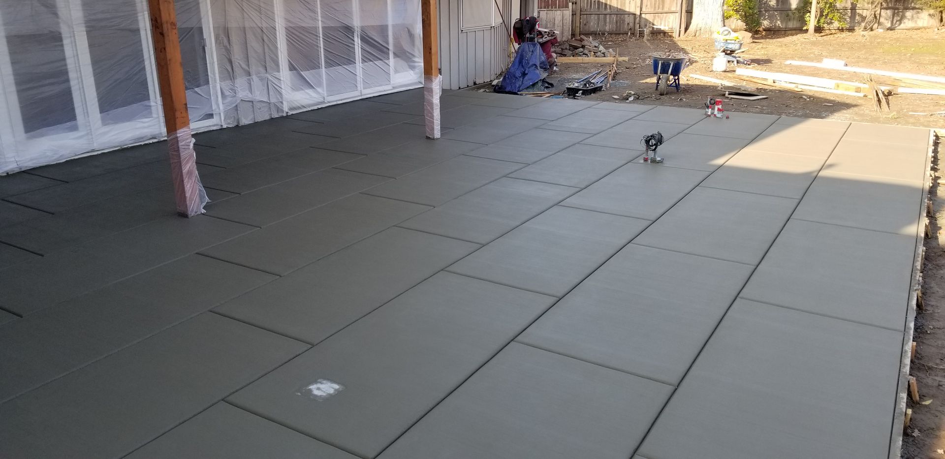 A concrete patio is being built in front of a house.