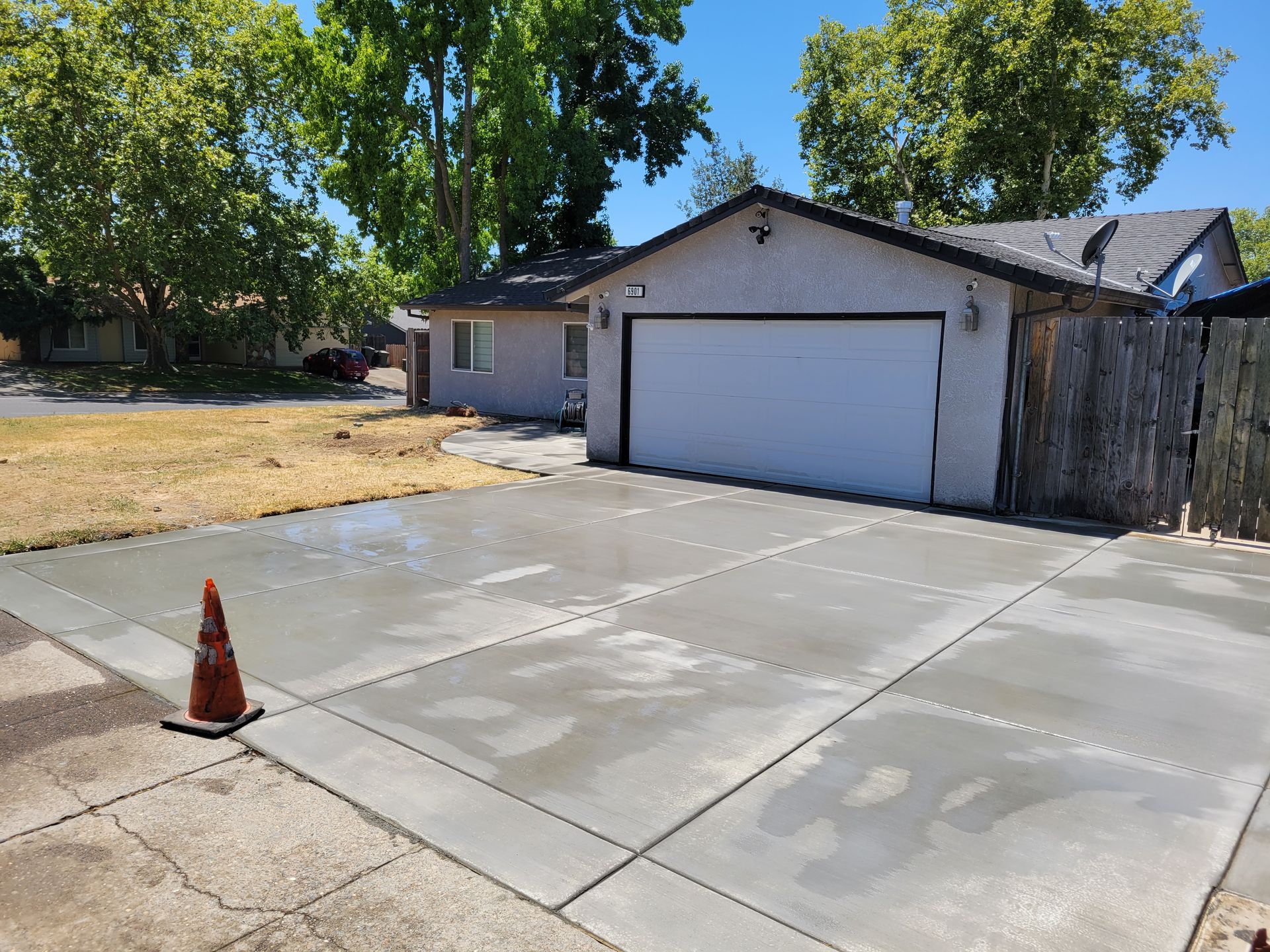 A concrete driveway is being built in front of a house.