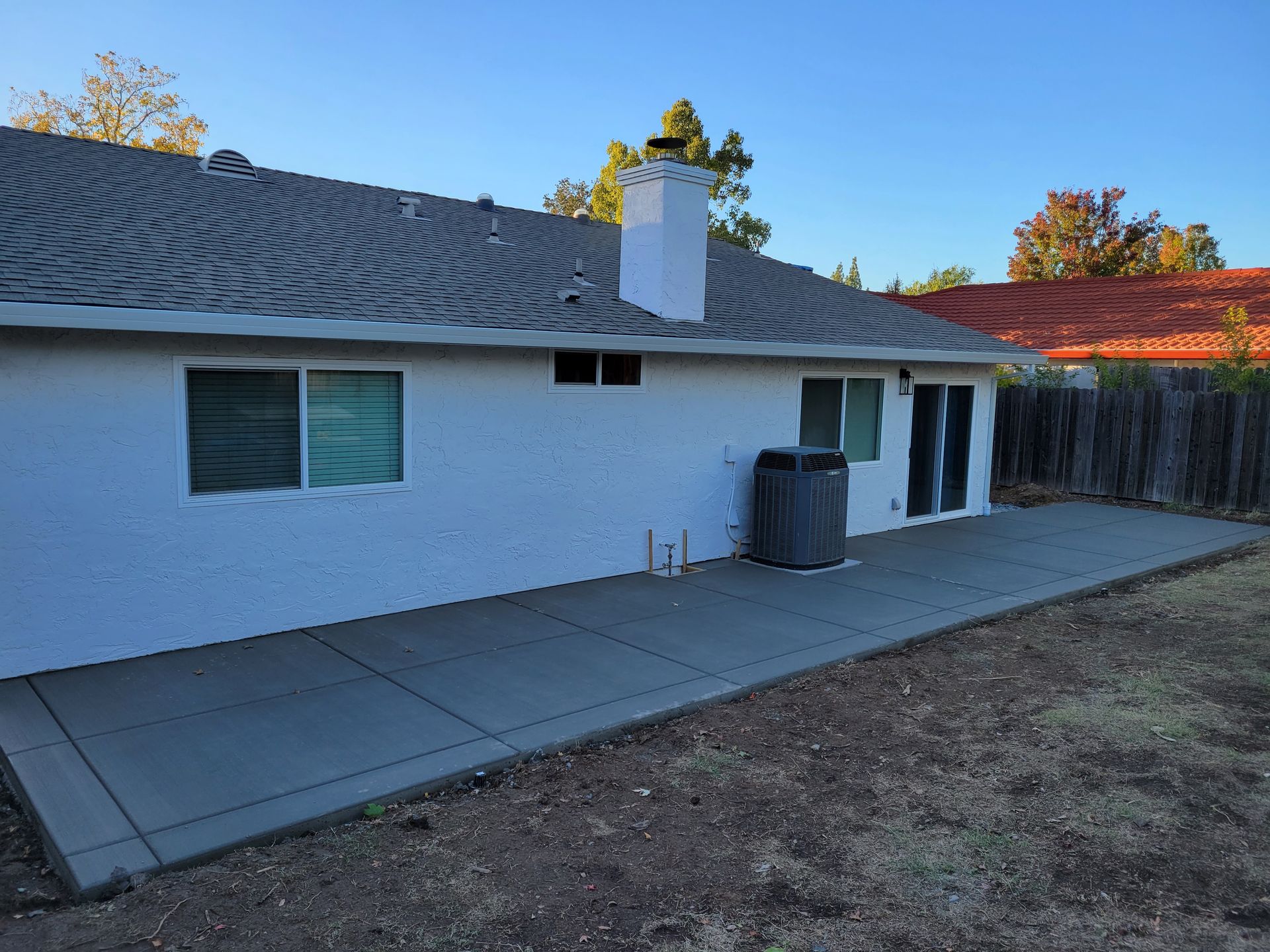 A white house with a concrete patio in front of it.