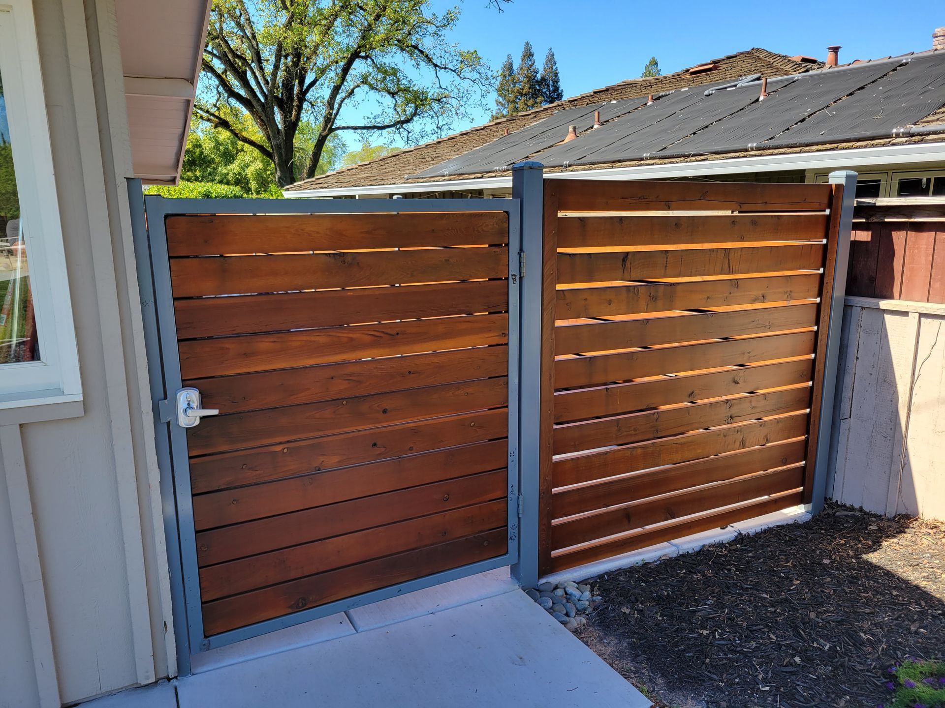 A wooden gate is sitting in front of a house.