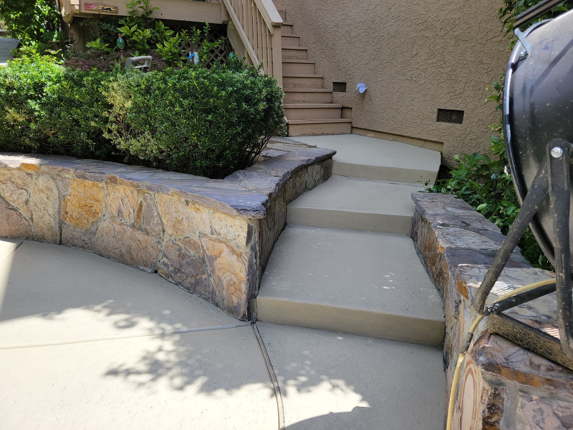 A concrete walkway with stairs leading up to a house.
