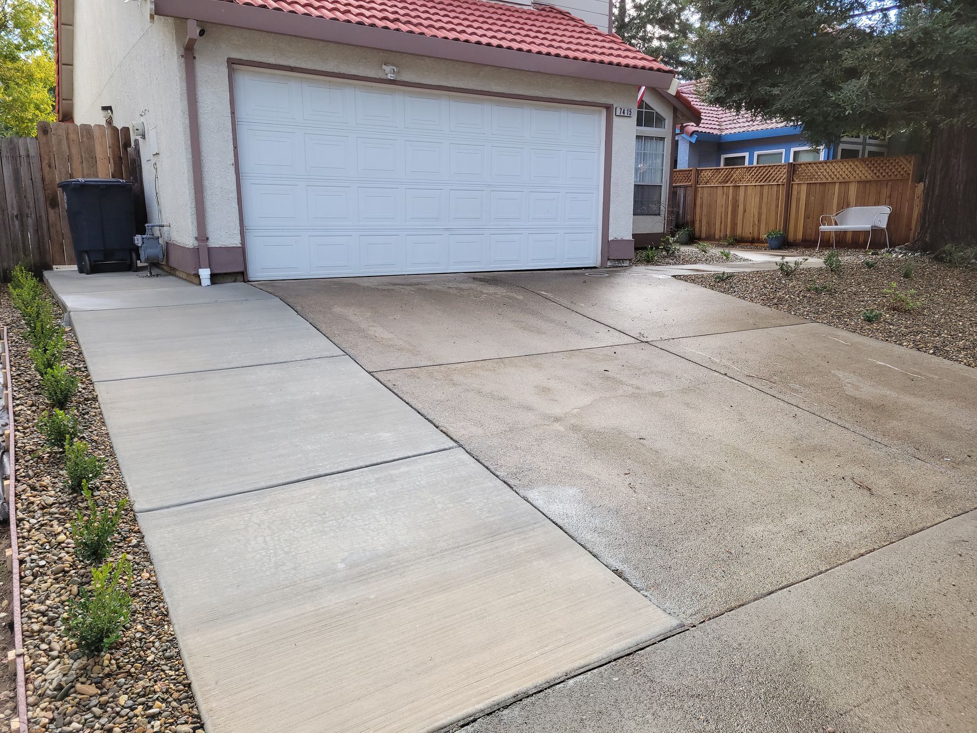 A concrete driveway leading to a white garage door