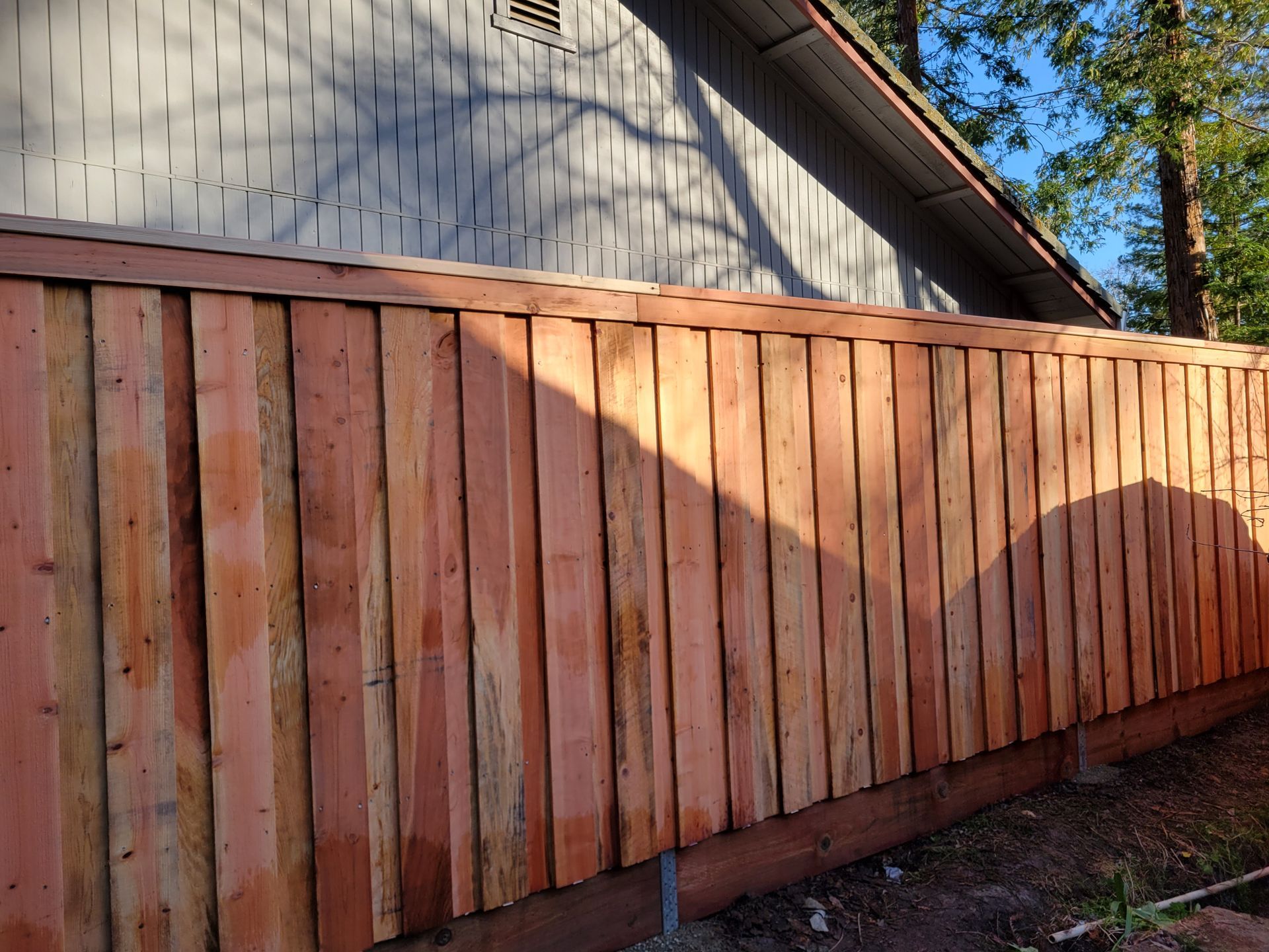 A wooden fence is sitting in front of a house.