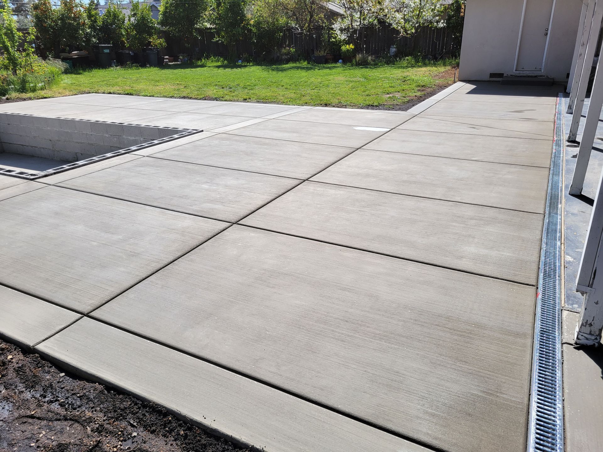 A concrete driveway is being built in a backyard.