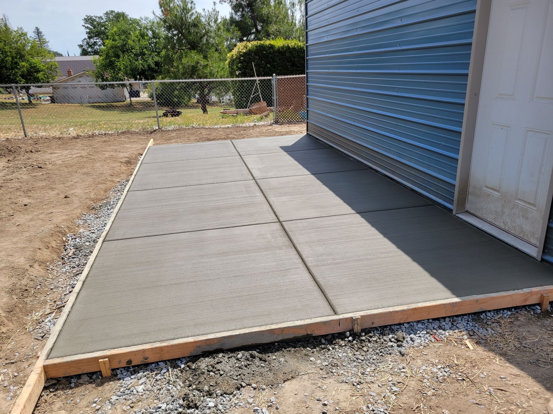 A concrete driveway is being built in front of a garage.