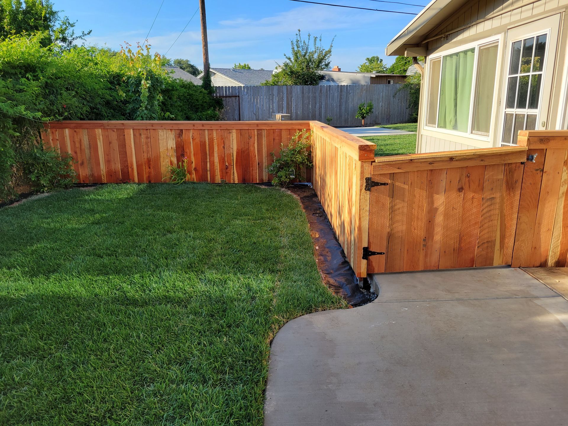 There is a wooden fence in the backyard of a house.