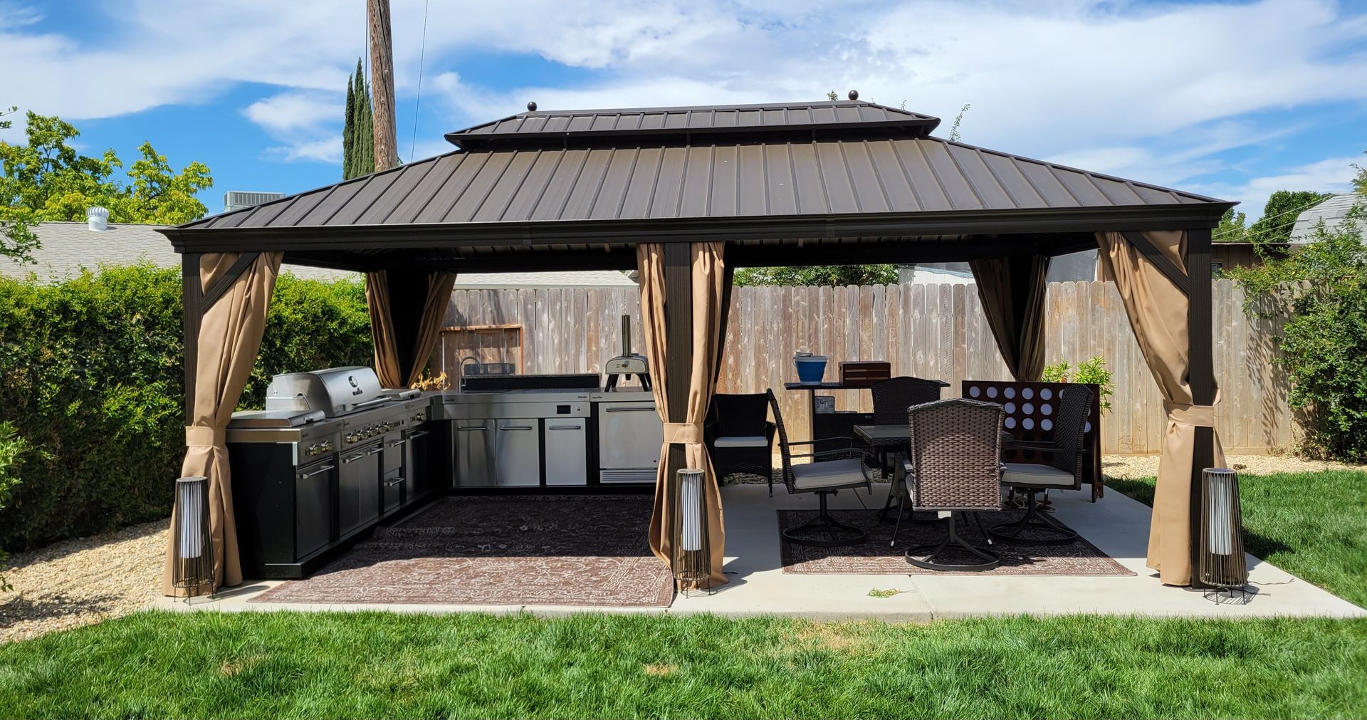 There is a gazebo with a kitchen and dining area underneath it.