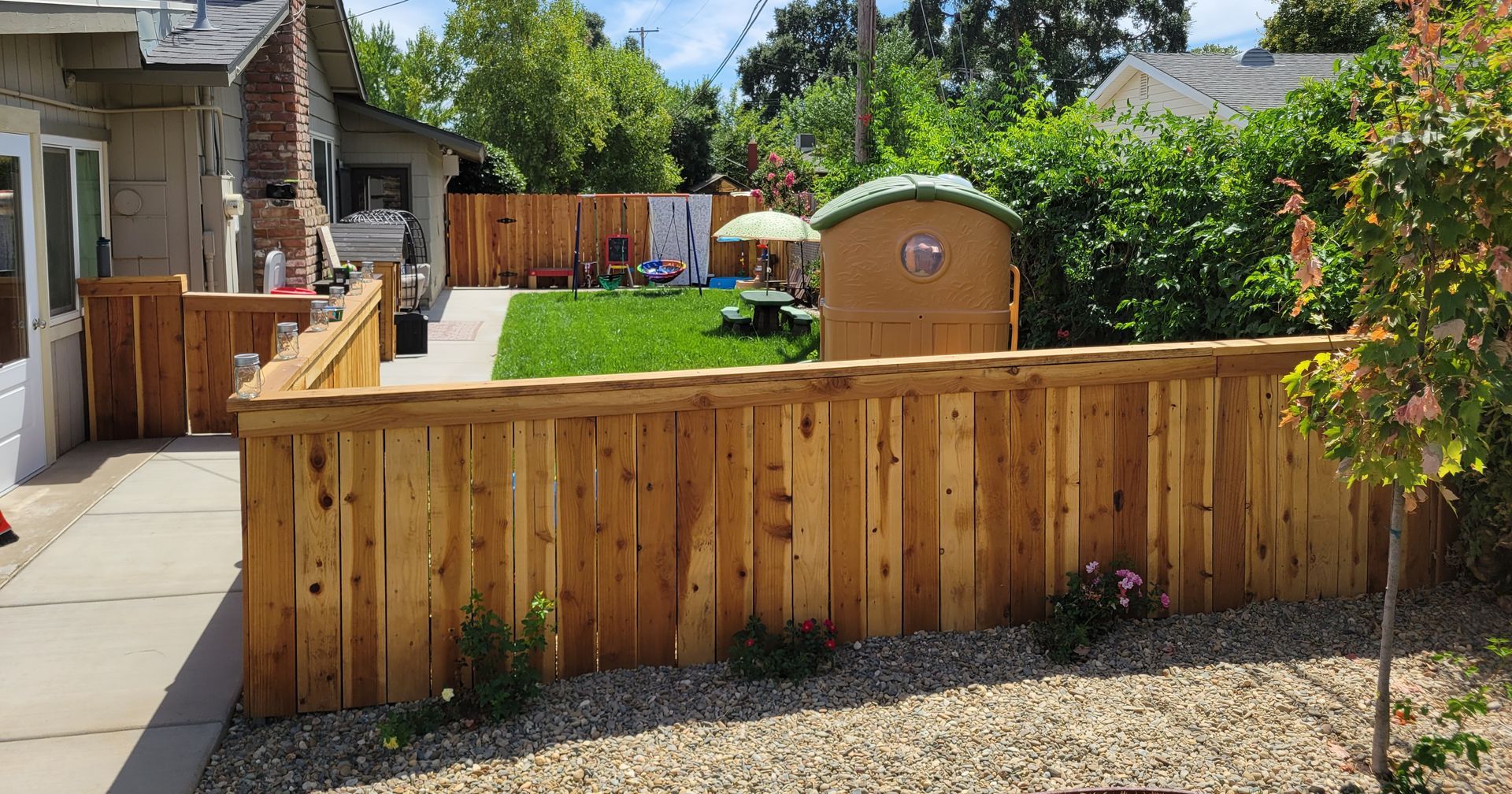There is a wooden fence in the backyard of a house.