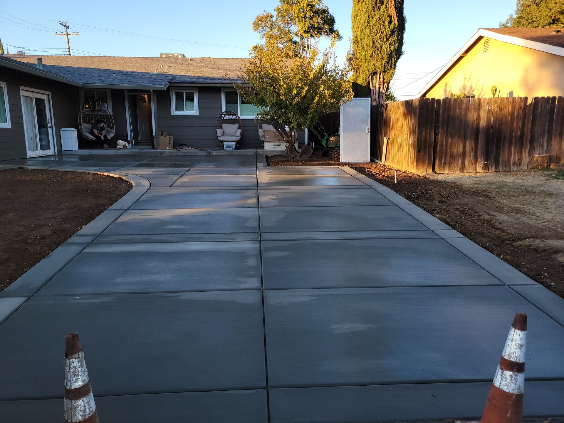 A concrete driveway is being built in front of a house
