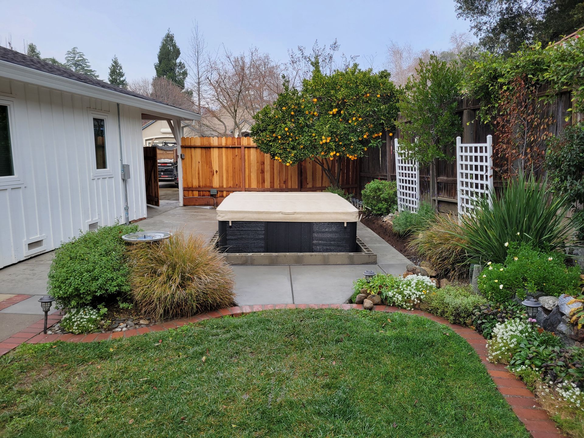 There is a hot tub in the backyard of a house.