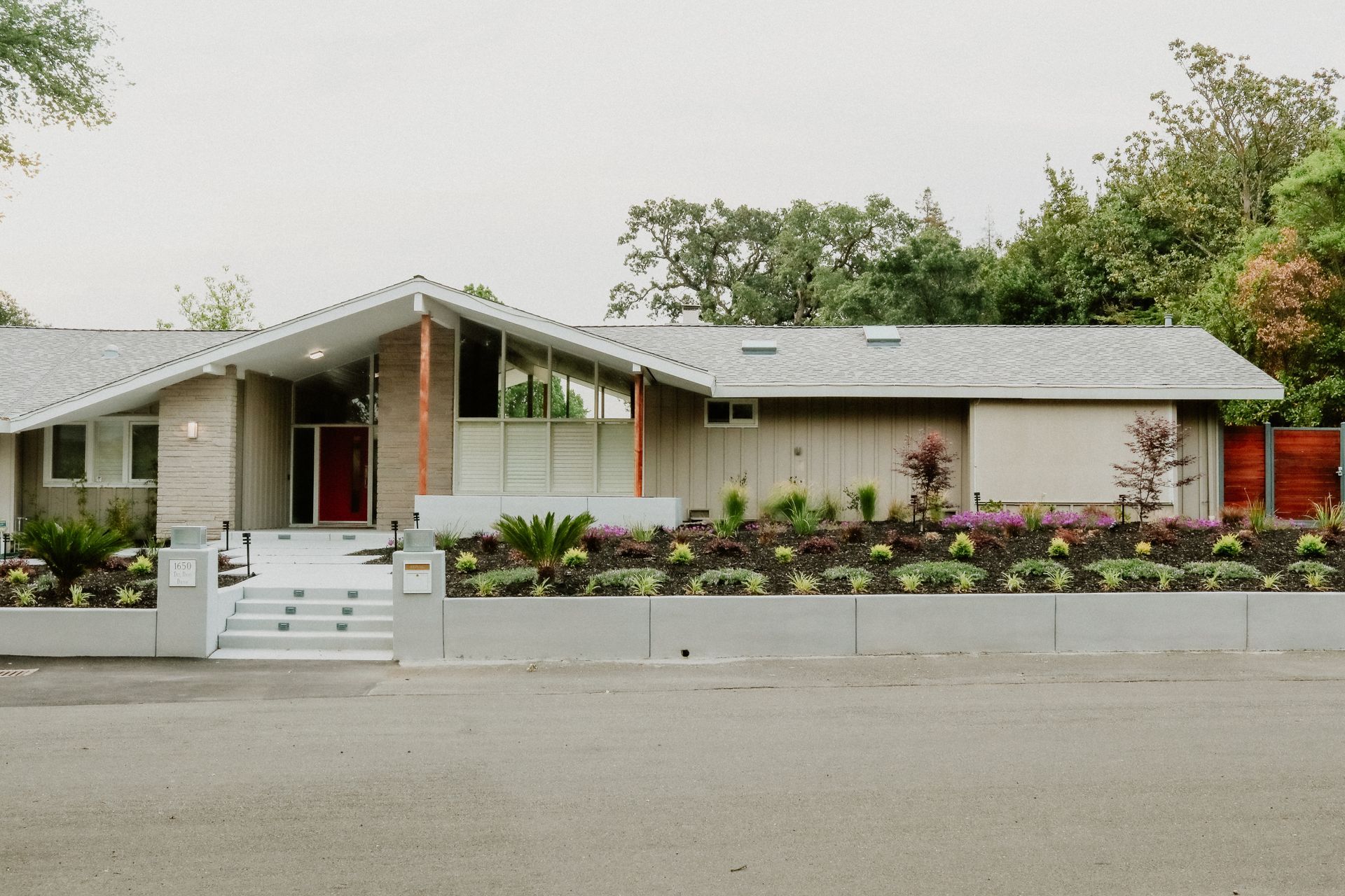 A house with a gray roof and a red door
