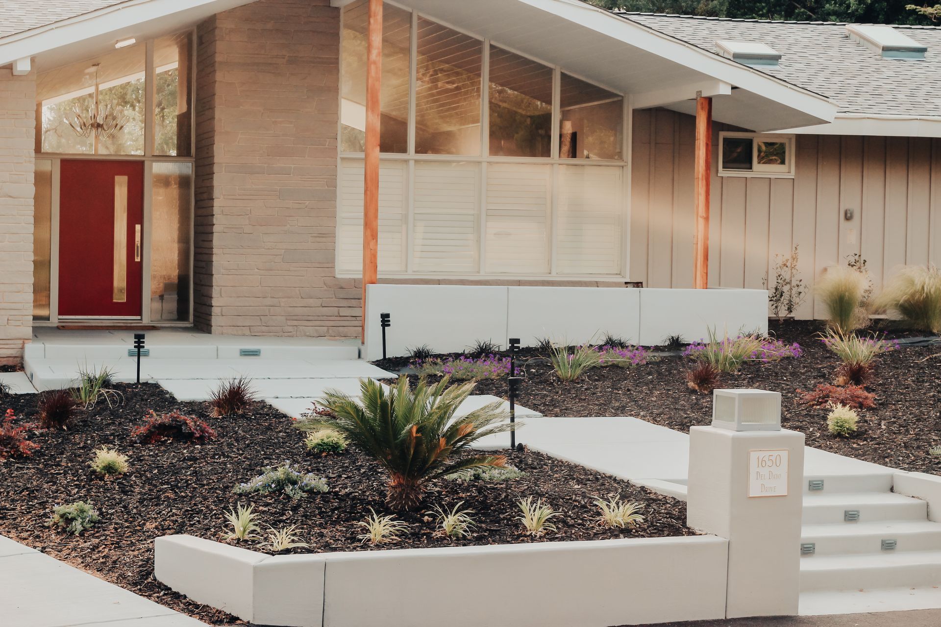 A house with a red door and a walkway in front of it.