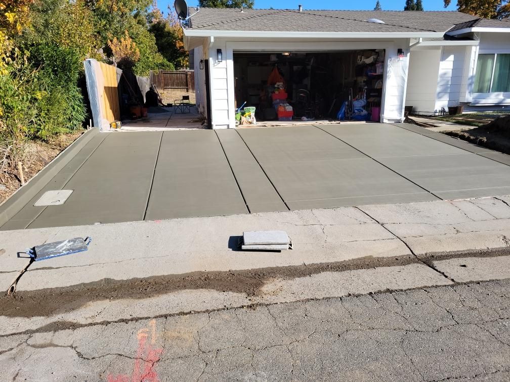 A concrete driveway is being built in front of a house.