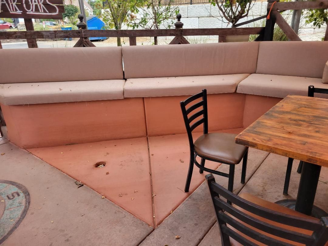 A patio with a couch and chairs and a wooden table