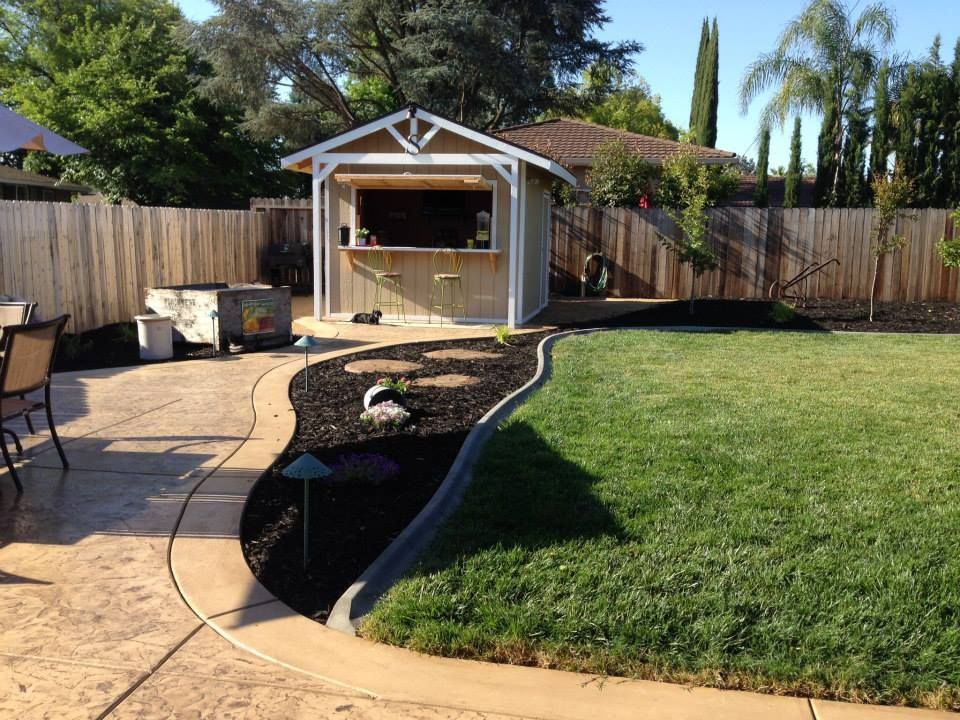 A backyard with a shed in the middle of it