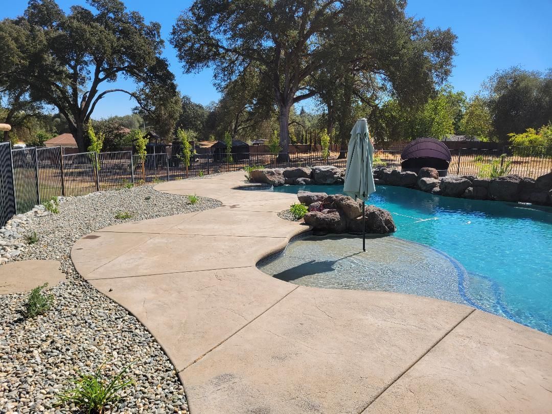 A large swimming pool with a concrete walkway leading to it