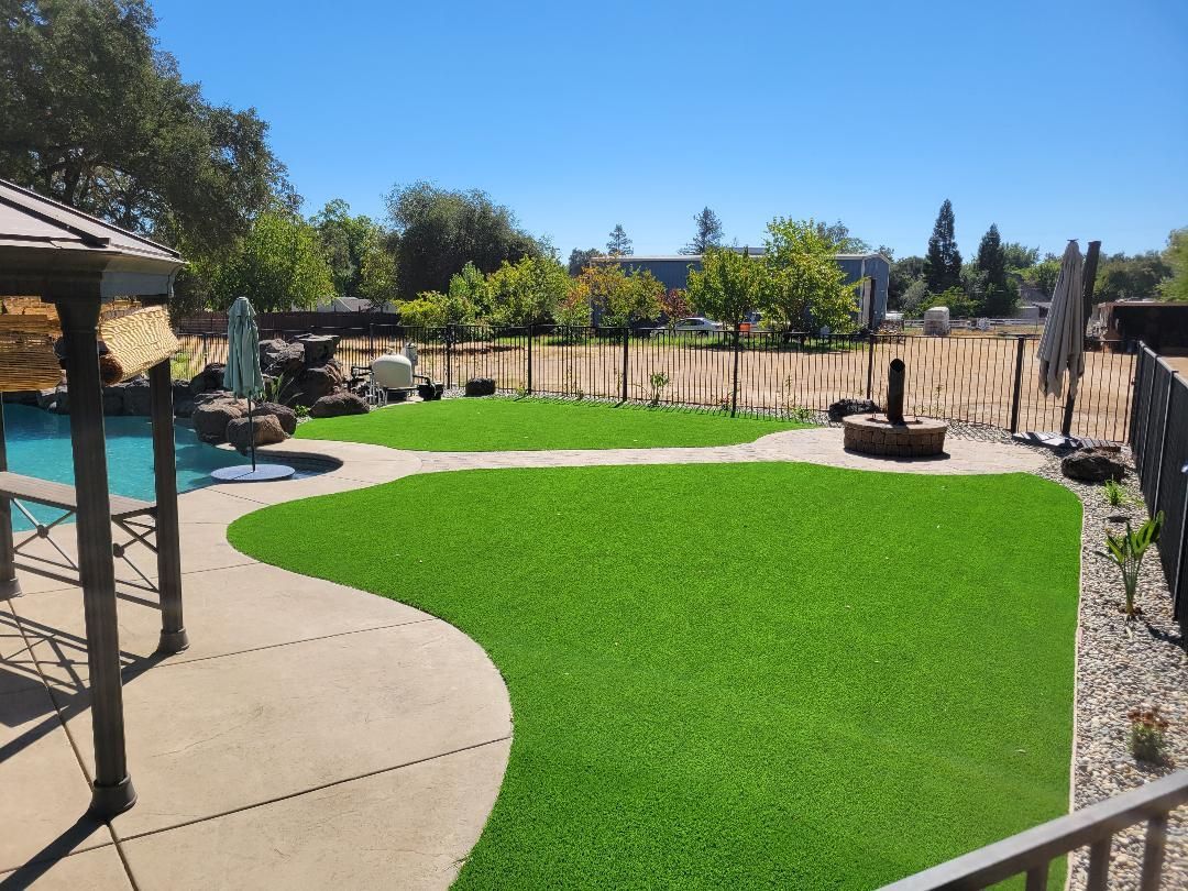 A large lawn with a swimming pool in the background