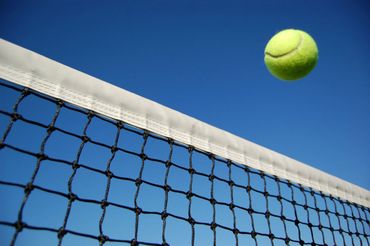 Palline da tennis, una racchetta di tennis, una struttura in metallo e vista della rete da lontano