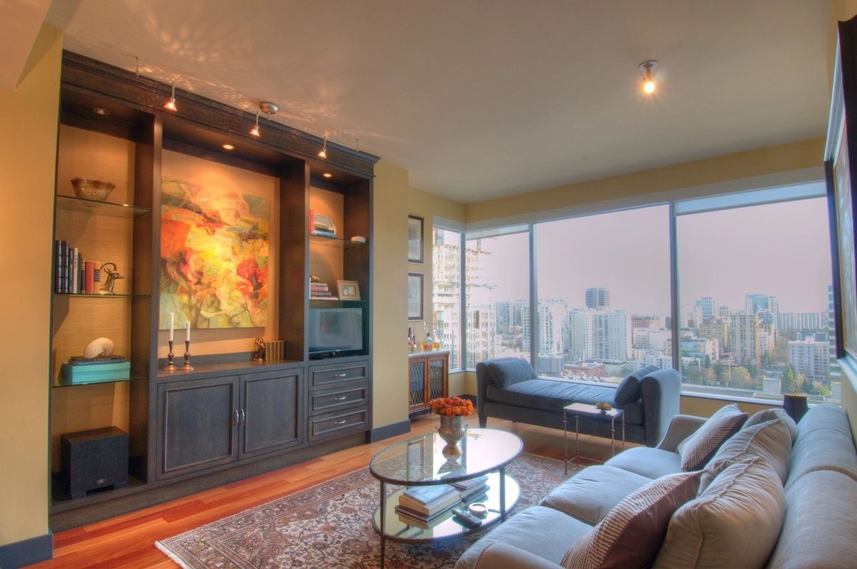 A living room with a couch , coffee table and a painting on the wall.