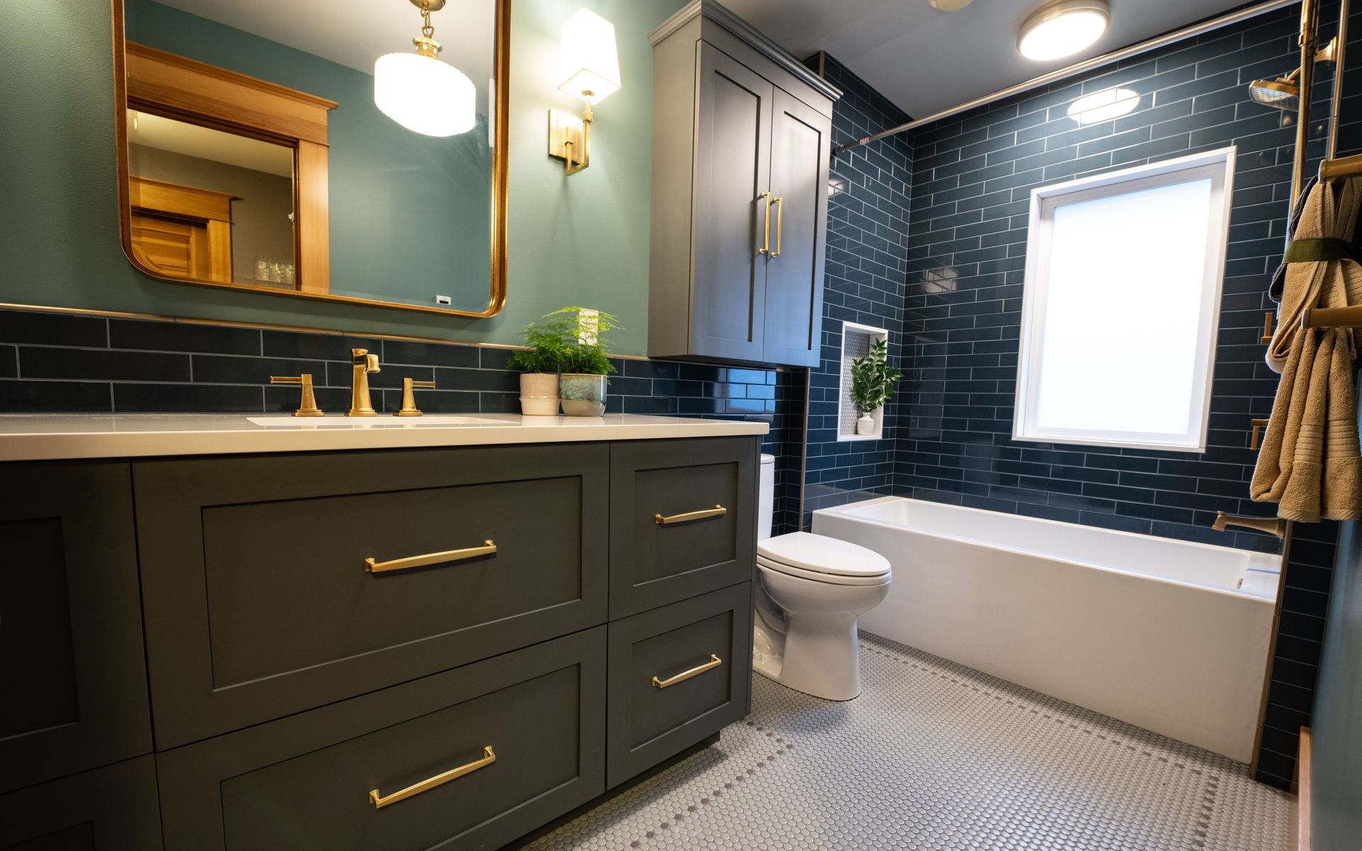 A bathroom with a sink , toilet , tub and mirror.