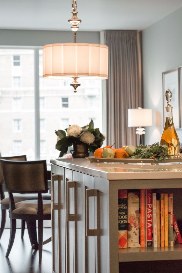 A kitchen with a large island and a shelf full of books including one called pasta