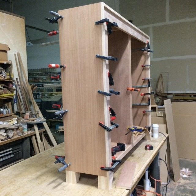 A wooden cabinet is being built in a workshop