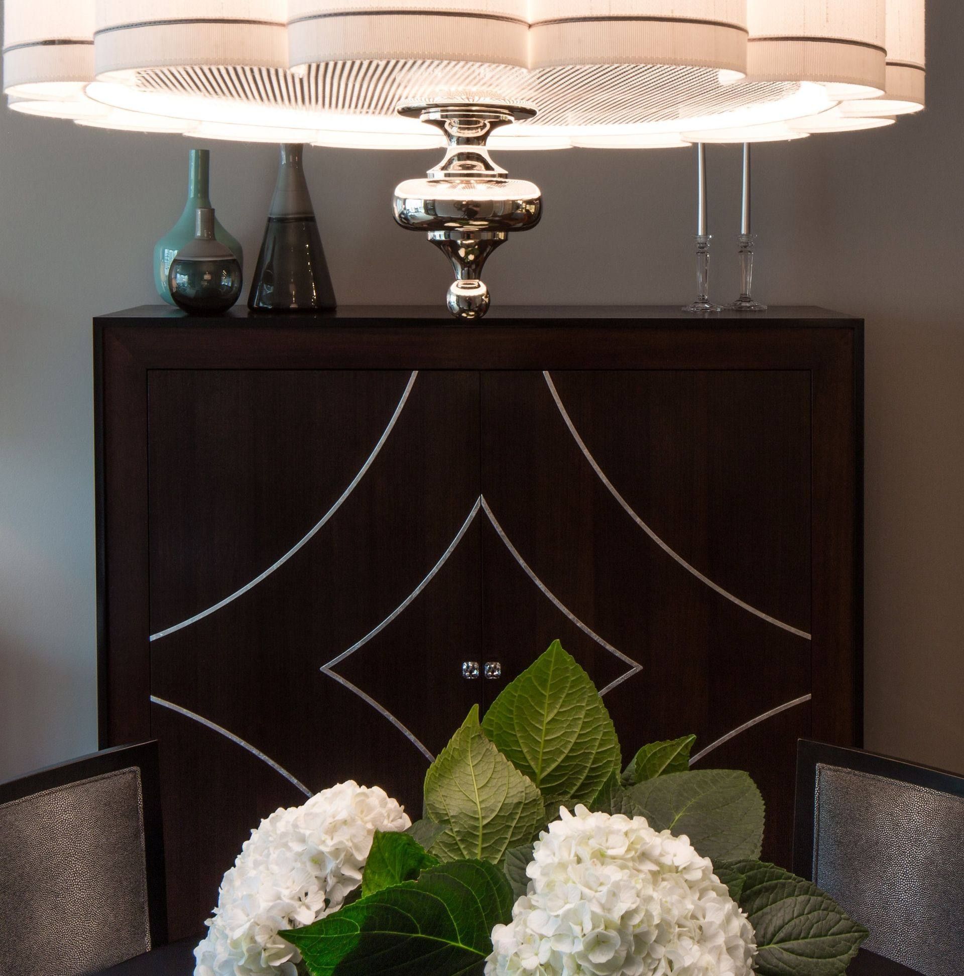 A dining room table with a vase of white flowers on it