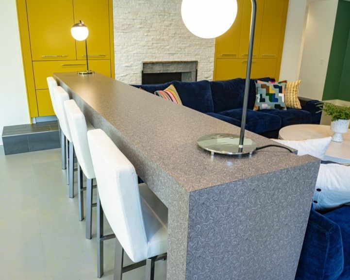 A living room with a blue couch and a long counter