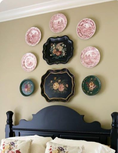 Plates are hanging on a wall above a bed