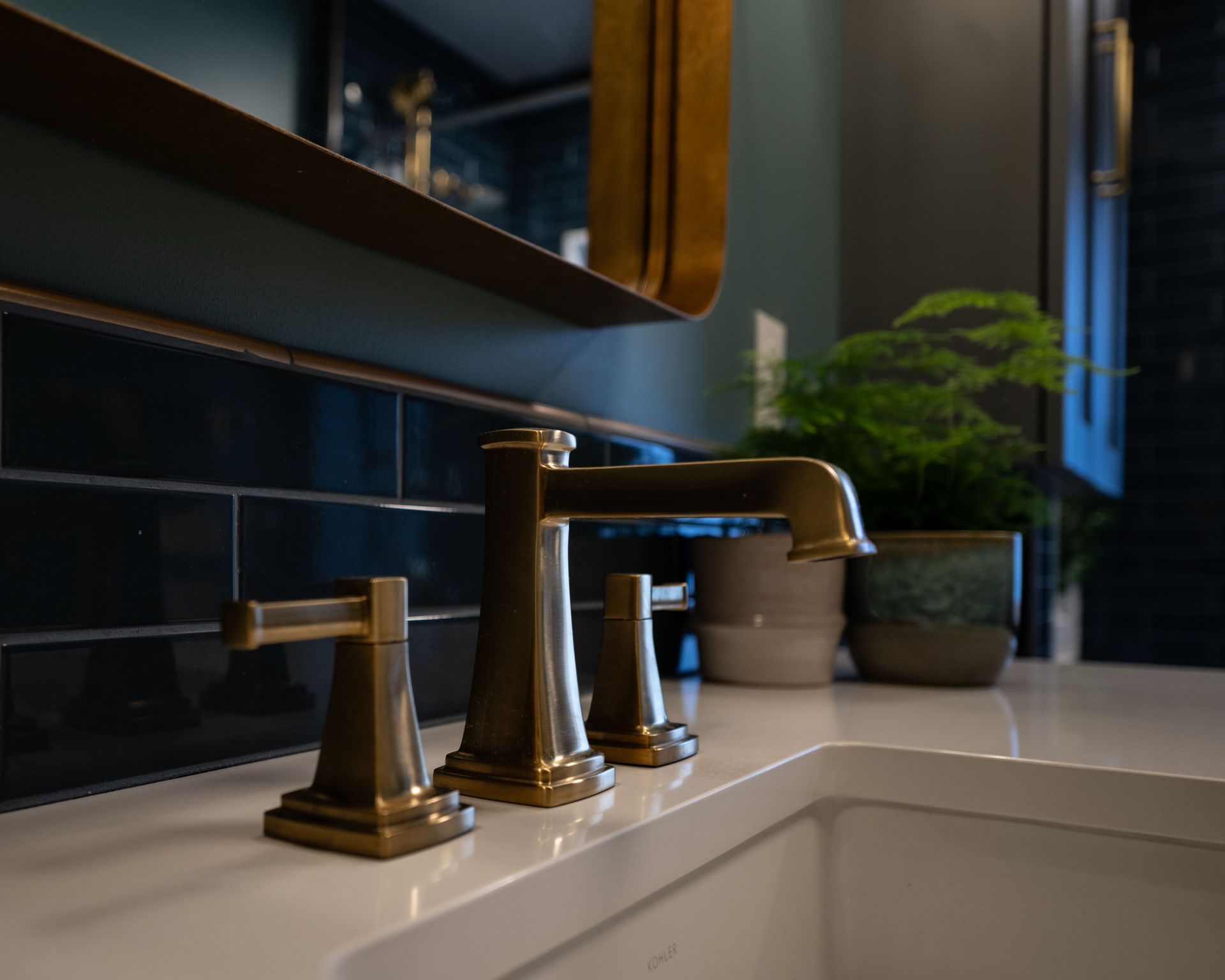 A bathroom sink with brass faucets and a mirror.