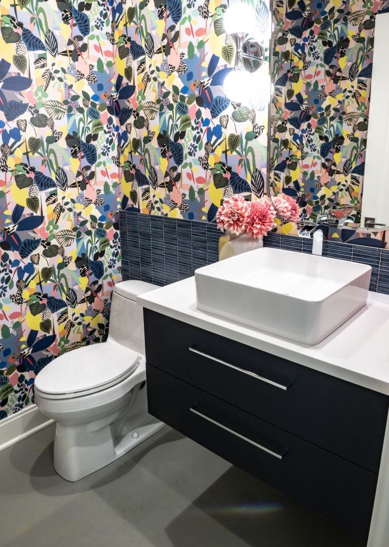 A bathroom with a toilet , sink and mirror.