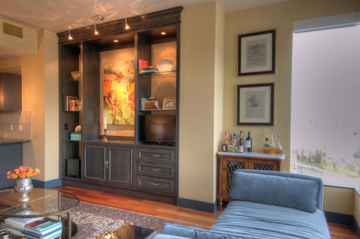 A living room with a blue couch , a coffee table , and a bar.