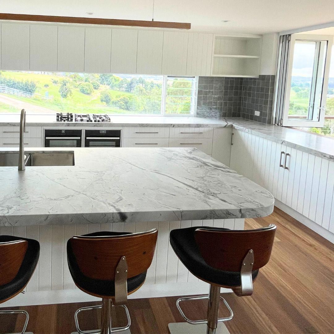 A Kitchen With A Marble Counter Top And Stools — Ben Lynch Cabinetmaking in South Lismore, NSW