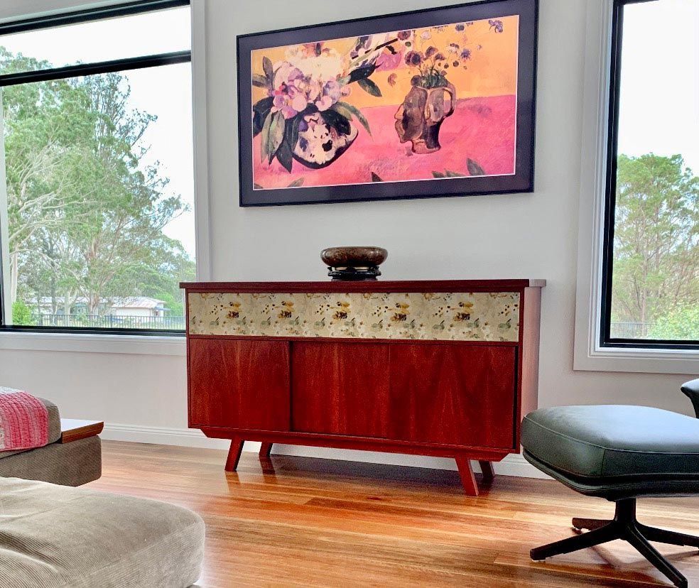 A Living Room With A Painting On The Wall Above A Wooden Dresser — Ben Lynch Cabinetmaking in Byron Bay, NSW