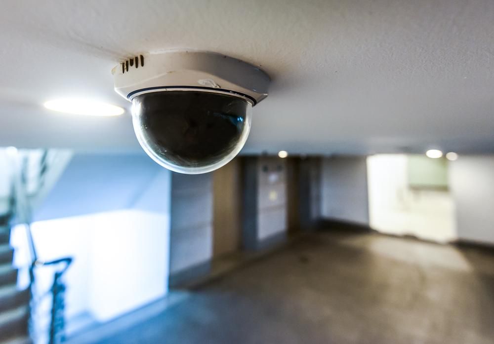 A Security Camera Is Mounted on The Ceiling of A Building — Firewerx In Dubbo, NSW